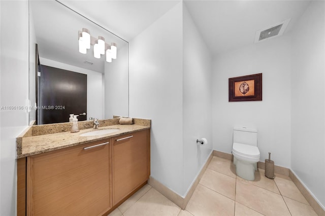 bathroom with tile patterned flooring, vanity, and toilet