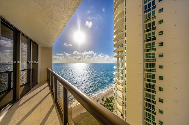 balcony featuring a beach view and a water view