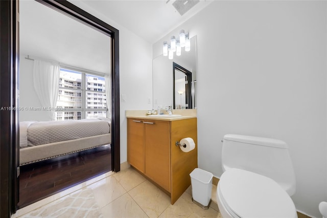 bathroom with hardwood / wood-style flooring, vanity, and toilet