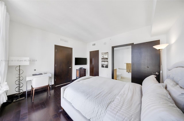 bedroom with dark hardwood / wood-style flooring and ensuite bath