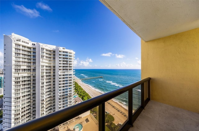 balcony featuring a water view and a beach view