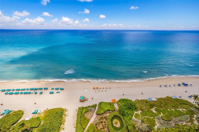 birds eye view of property with a water view and a beach view