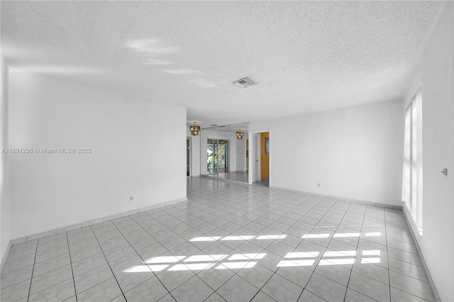 empty room featuring light tile patterned floors and a textured ceiling