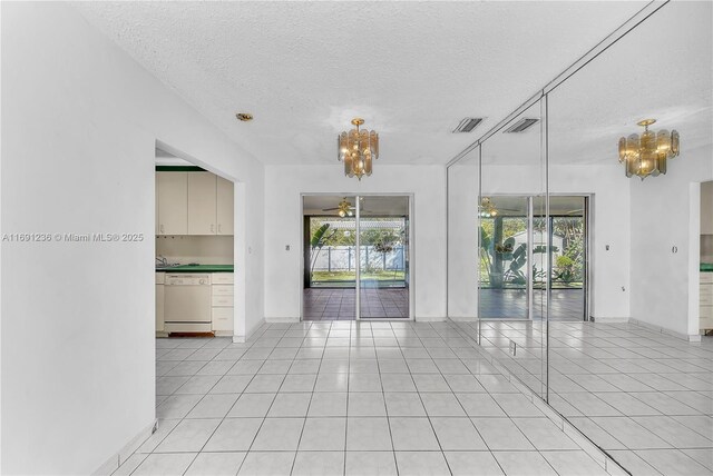 kitchen featuring light tile patterned flooring, white appliances, and a notable chandelier