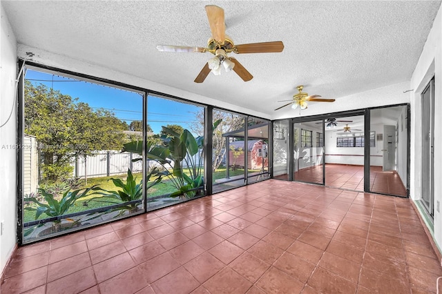 unfurnished sunroom featuring ceiling fan