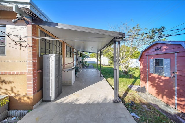 view of patio / terrace featuring a carport and a shed