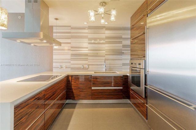 kitchen featuring island exhaust hood, appliances with stainless steel finishes, pendant lighting, and sink