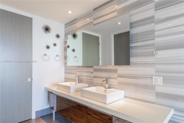 1100 Biscayne Blvd Unit 4502, Miami, FL 33132 - bathroom featuring double vanity, decorative backsplash, and tile walls