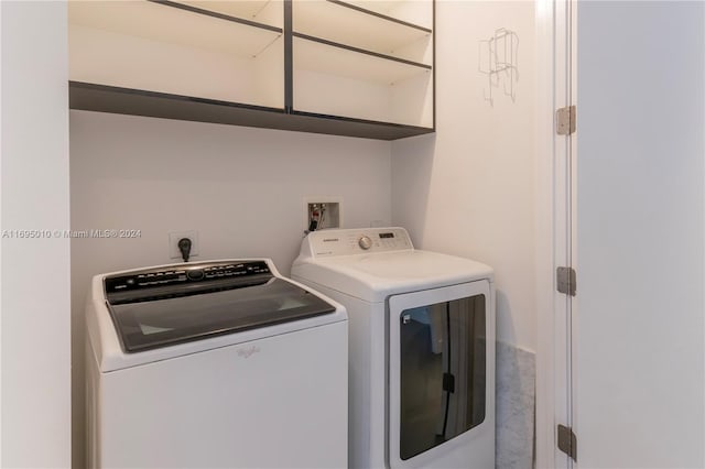 clothes washing area with washing machine and dryer