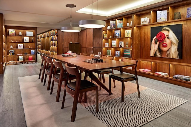 dining room featuring a raised ceiling, built in features, and hardwood / wood-style flooring