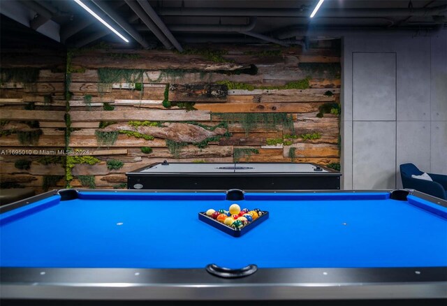 recreation room with wooden walls and billiards