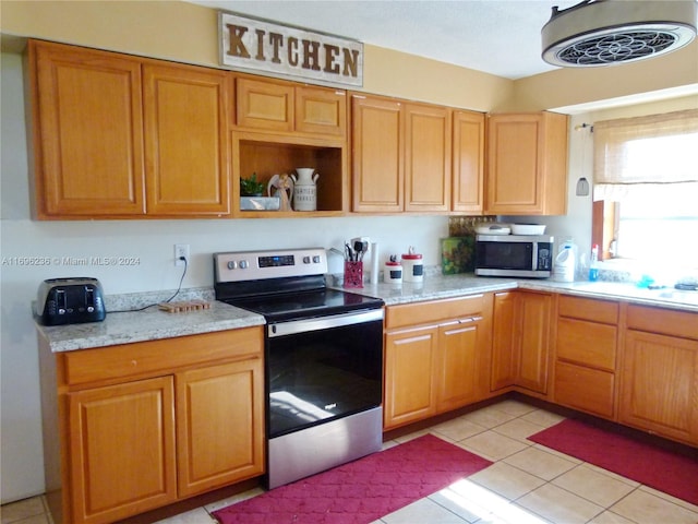 kitchen with light stone counters, light tile patterned floors, and appliances with stainless steel finishes