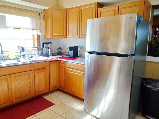 kitchen with light tile patterned floors and stainless steel refrigerator