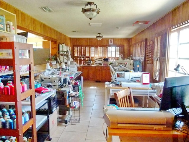 miscellaneous room featuring a wealth of natural light, light tile patterned floors, and wood walls