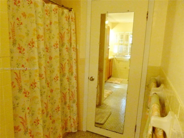 bathroom featuring tile patterned flooring and tile walls