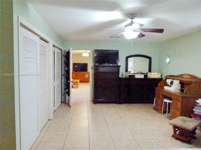 tiled bedroom featuring multiple closets and ceiling fan