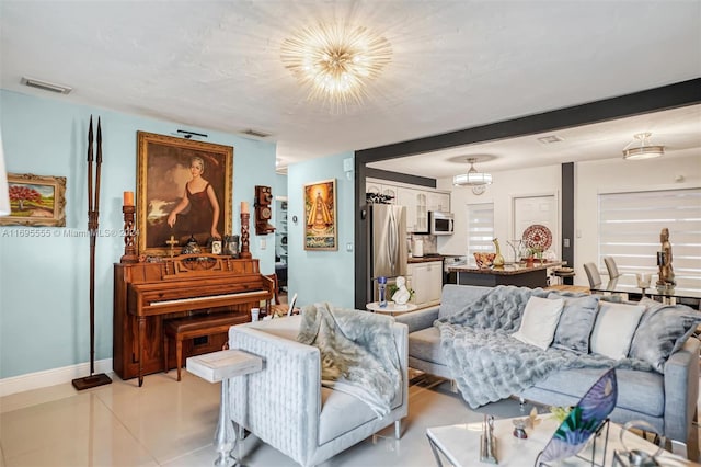 living room featuring light tile patterned floors and an inviting chandelier