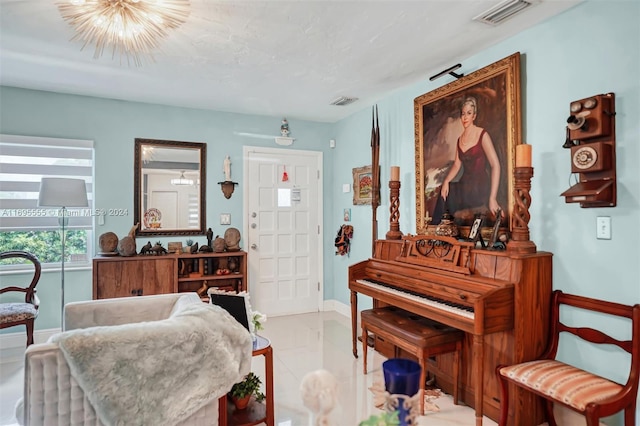 sitting room with light tile patterned floors and a notable chandelier