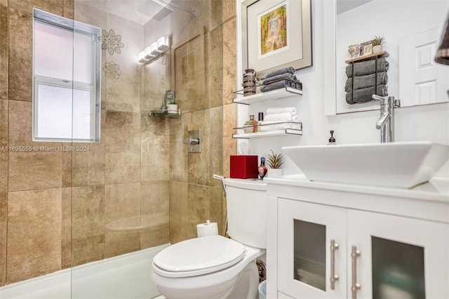 bathroom featuring vanity, toilet, and a tile shower