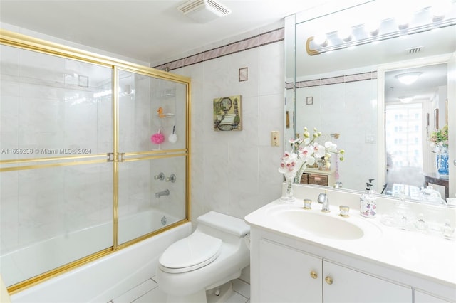 full bathroom featuring vanity, tile patterned flooring, toilet, enclosed tub / shower combo, and tile walls