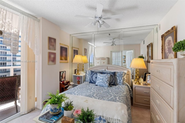 carpeted bedroom featuring access to outside, ceiling fan, and a textured ceiling