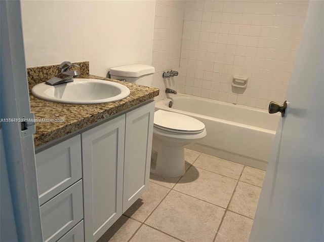 full bathroom featuring tiled shower / bath, tile patterned flooring, vanity, and toilet