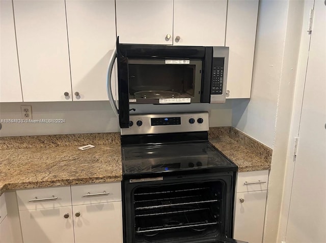 kitchen with white cabinets, light stone countertops, and stainless steel appliances