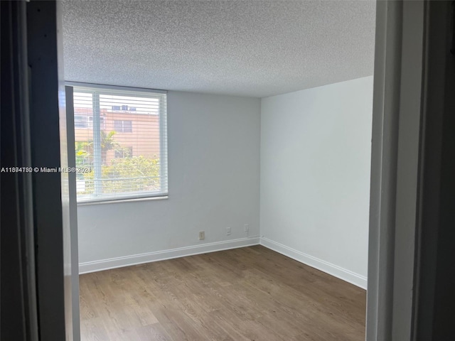 empty room featuring light hardwood / wood-style flooring and a textured ceiling