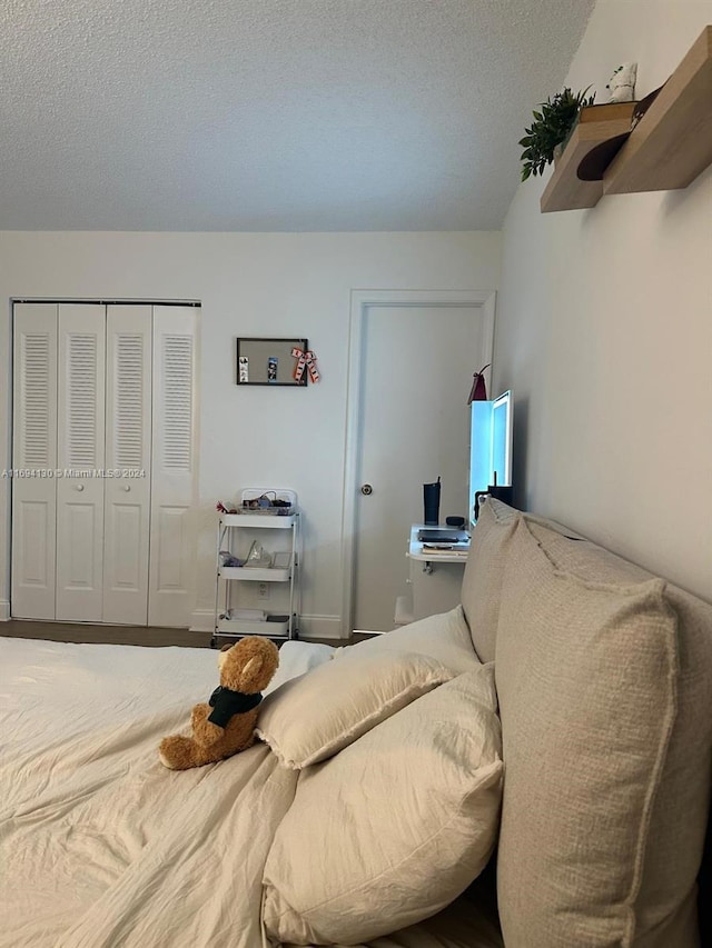 bedroom with a textured ceiling and a closet