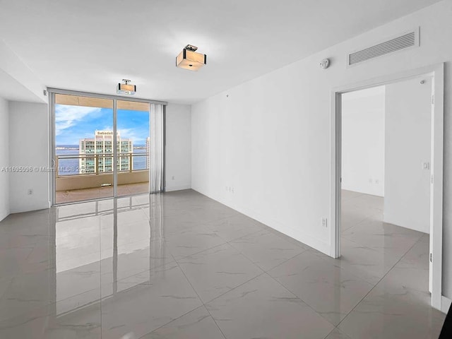 1080 Brickell Ave Unit 3604, Miami, FL 33131 - unfurnished room with a wall of windows, marble look tile flooring, and baseboards