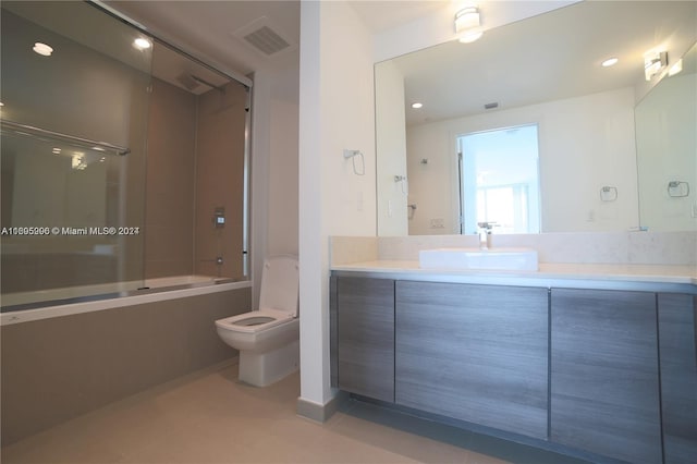 full bathroom with combined bath / shower with glass door, tile patterned floors, vanity, and toilet