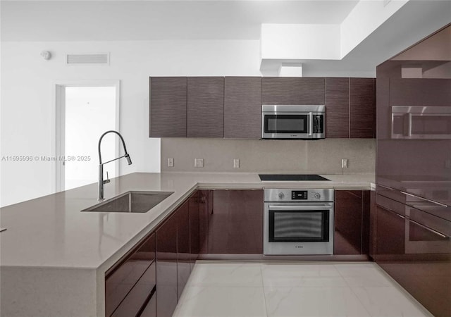 1080 Brickell Ave Unit 3604, Miami, FL 33131 - kitchen featuring stainless steel appliances, a sink, modern cabinets, a peninsula, and light marble finish flooring