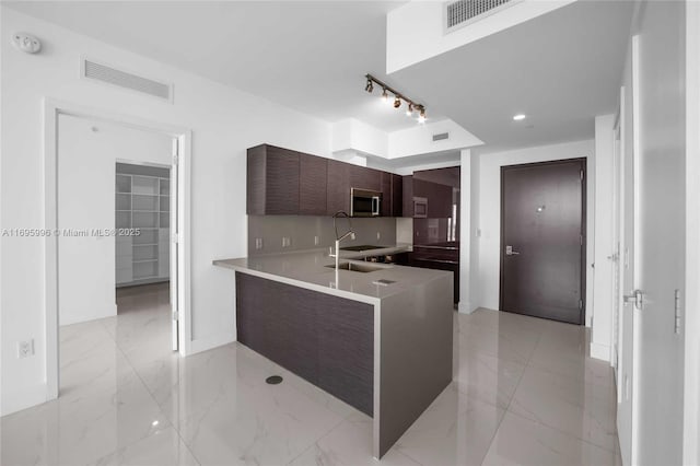 1080 Brickell Ave Unit 3604, Miami, FL 33131 - kitchen with stainless steel microwave, modern cabinets, light marble finish floors, a peninsula, and light countertops