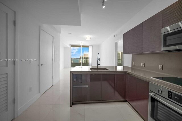 1080 Brickell Ave Unit 3604, Miami, FL 33131 - kitchen with stainless steel appliances, a sink, modern cabinets, a peninsula, and light countertops