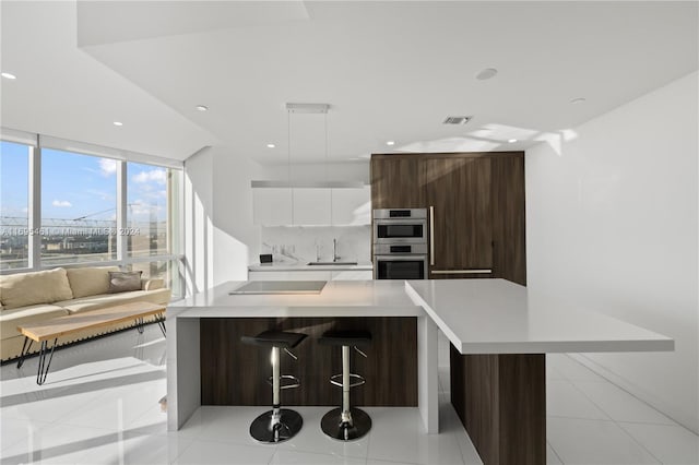 kitchen featuring white cabinetry, double oven, decorative light fixtures, decorative backsplash, and light tile patterned floors