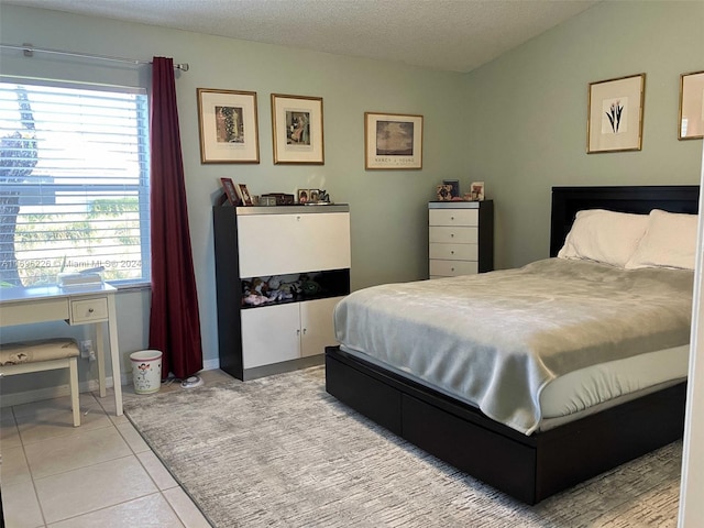 tiled bedroom featuring a textured ceiling and multiple windows