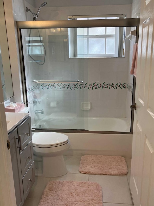 full bathroom featuring vanity, tile patterned floors, and bath / shower combo with glass door