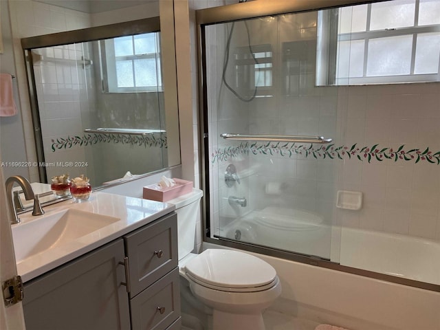 full bathroom featuring shower / bath combination with glass door, vanity, and toilet