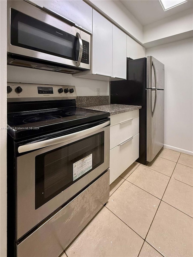 kitchen featuring white cabinetry, light tile patterned flooring, and stainless steel appliances