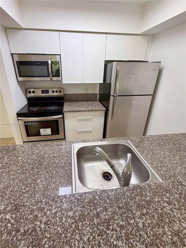 kitchen featuring white cabinetry, sink, and appliances with stainless steel finishes