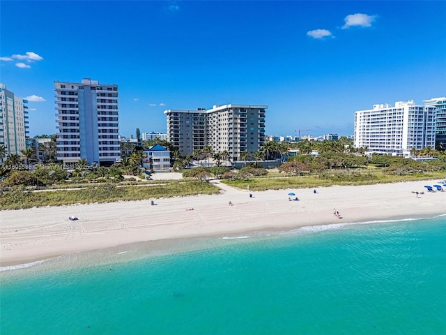 birds eye view of property featuring a water view and a beach view