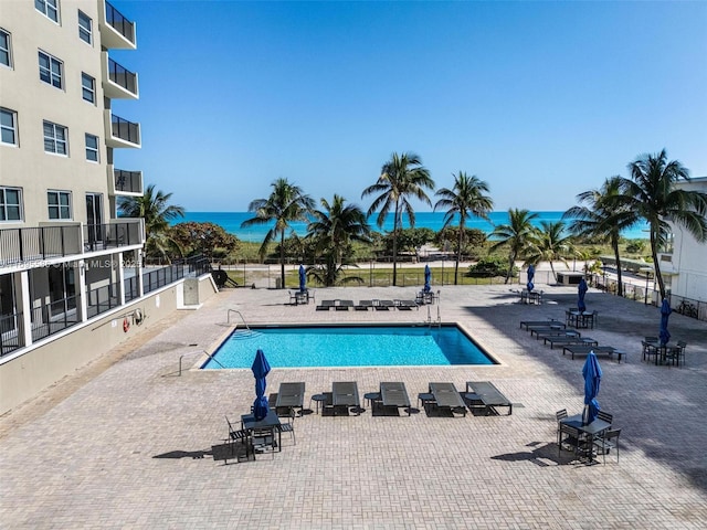 view of swimming pool with a water view and a patio