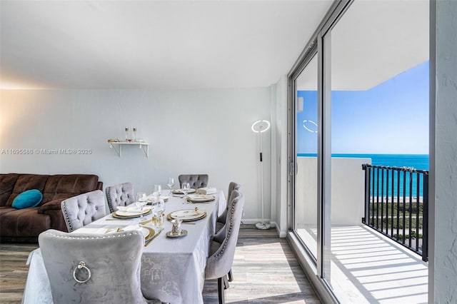 dining room with hardwood / wood-style floors and a water view