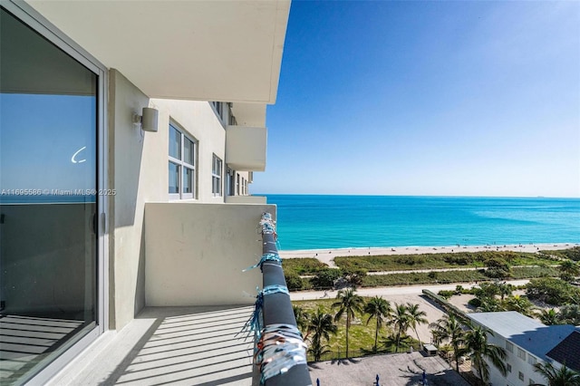 balcony featuring a view of the beach and a water view