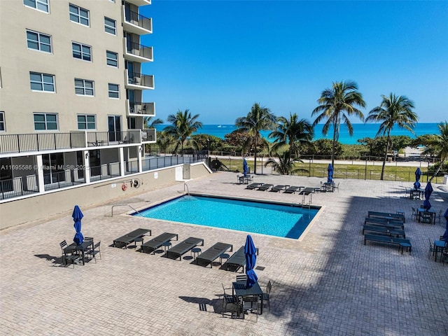 view of swimming pool featuring a patio area and a water view