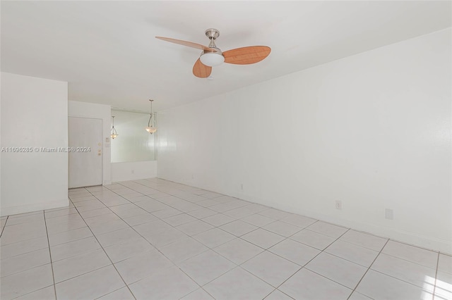 tiled spare room with ceiling fan