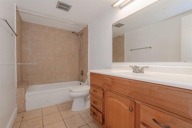 full bathroom featuring tile patterned flooring, vanity, tiled shower / bath combo, and toilet