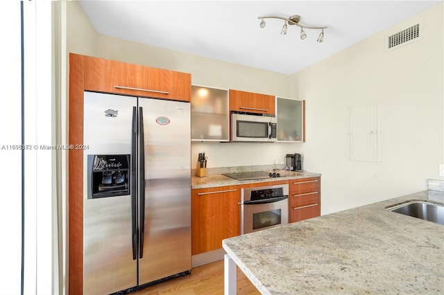 kitchen with light hardwood / wood-style floors, sink, and appliances with stainless steel finishes