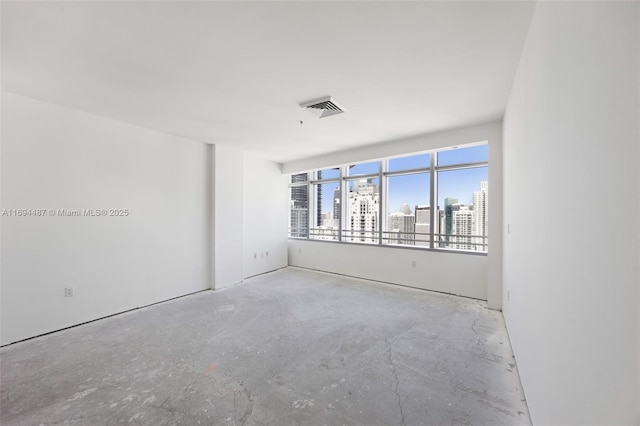 empty room with visible vents and a city view