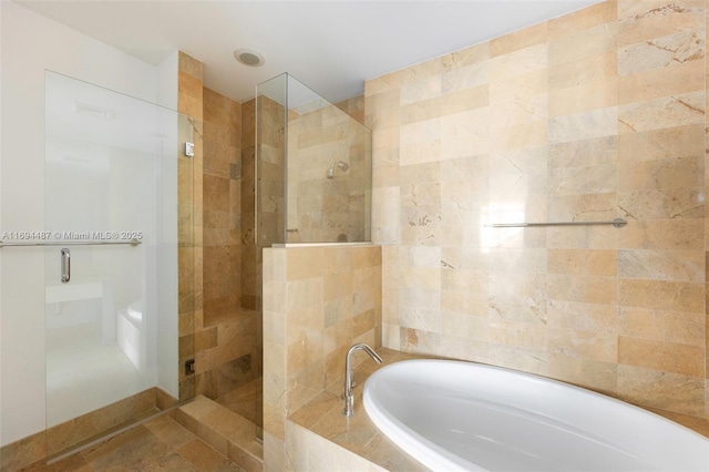 bathroom featuring a shower stall and a bath